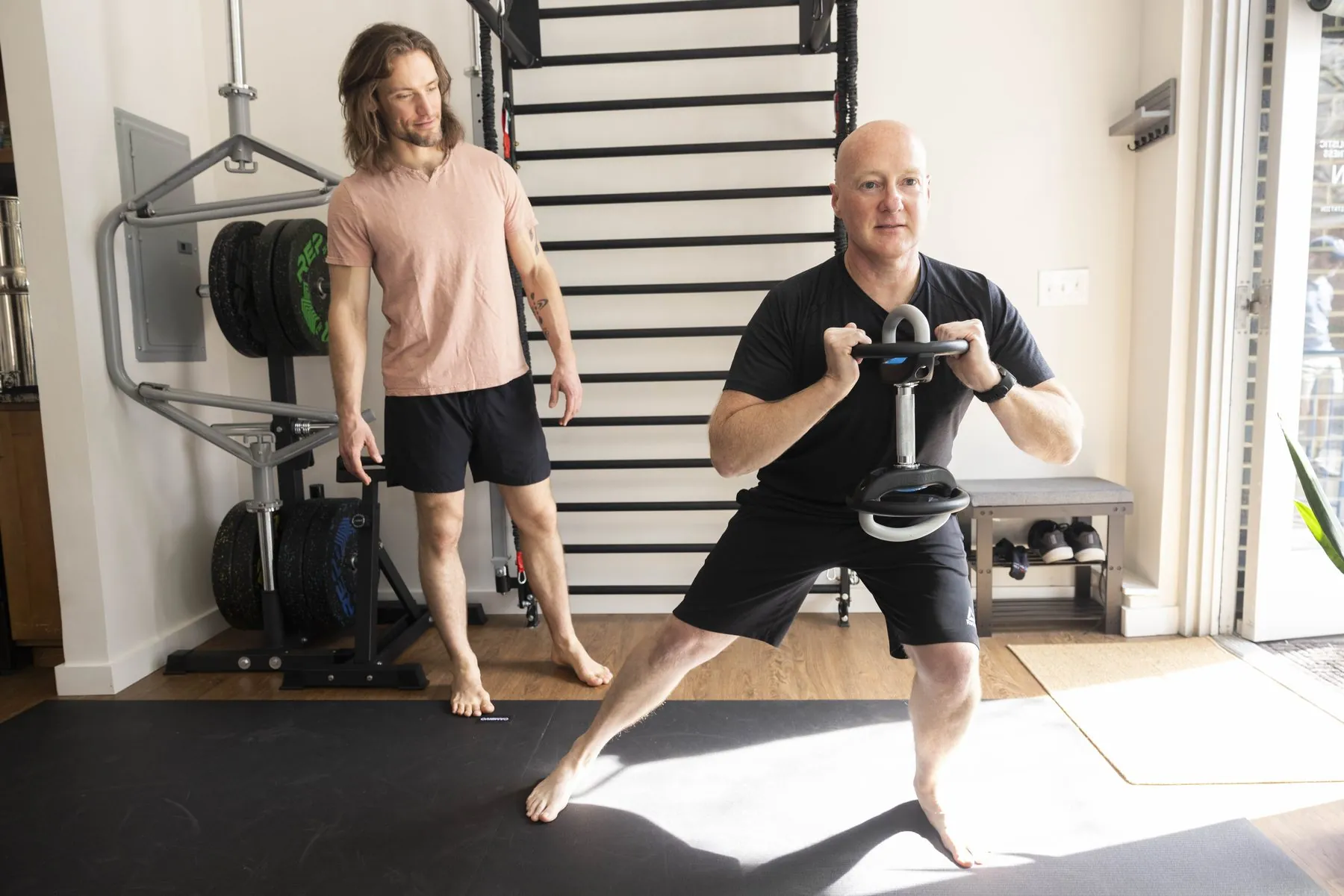 Evan coaching a client through a movement in his private studio